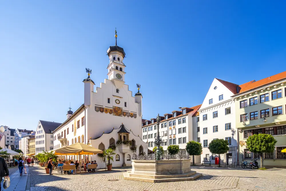 Una piazza cittadina di Kempten con una torre dell'orologio sullo sfondo.